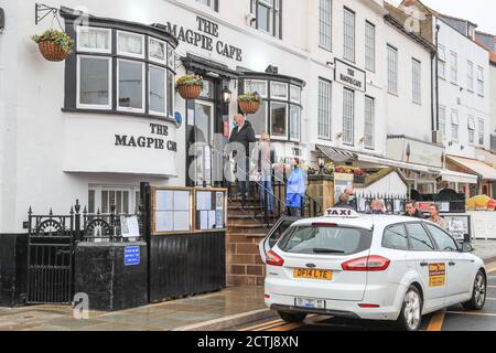 Vor Whitby's berühmtem Magpie Cafe stehen die Leute Schlange Stockfoto