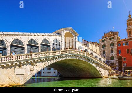 Venedig Stadtbild mit Rialtobrücke über Grand Canal Wasserstraße, venezianische Architektur farbenfrohe Gebäude, blauer Himmel an sonnigen Sommertagen. Region Venetien, Norditalien. Stockfoto