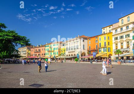 Verona, Italien, 12. September 2019: Piazza Bra Platz im historischen Stadtzentrum mit Reihe von alten bunten bunten Gebäuden Cafés und Restaurants, grüne Bäume und Wandertouristen, blauer Himmel Stockfoto