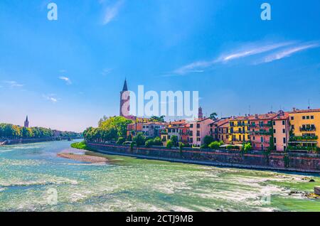 Verona Stadtbild mit Gebäuden auf der Böschung des Flusses Etsch, Glockenturm Campanile di Santa Anastasia katholische Kirche, historisches Stadtzentrum, blauer Himmel Hintergrund, Region Venetien, Norditalien Stockfoto