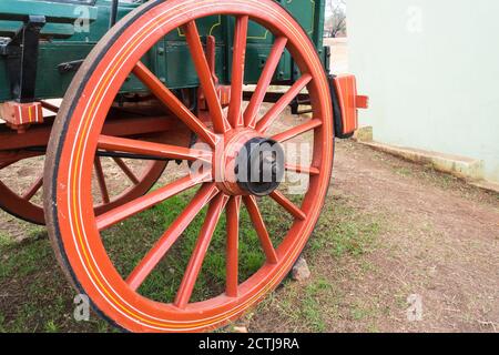 Nahaufnahme eines roten Holzrades und Speichen auf einem alten historischen Ochsenwagen in Pilgrims Rest, Südafrika Stockfoto