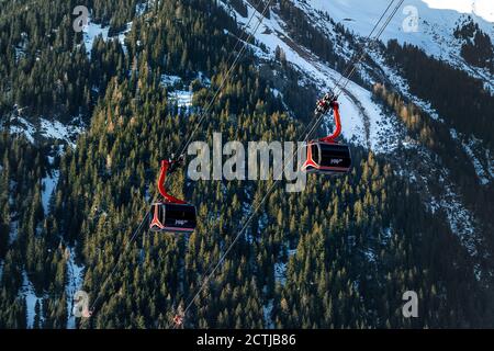 Ischgl, Österreich- 10. Januar 2018: Neue, moderne Großkabinenbahn PARDATSCHGRATBAHN gegen Waldberglandschaft im Luxus-österreicher Stockfoto