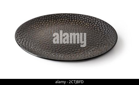 Side view of round black ceramic plate with textured surface isolated on a white background. Empty crockery for food design. Modern clay and ceramics. Stockfoto