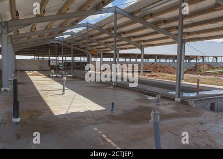 Betonboden mit Gebäude im Bau. Betonboden des Bodens. Bau des Hangars Stockfoto