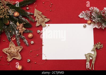 weihnachtliches Layout und weißes leeres Lettering-Blatt mit goldener Utensilien Auf rotem Stoffhintergrund Stockfoto