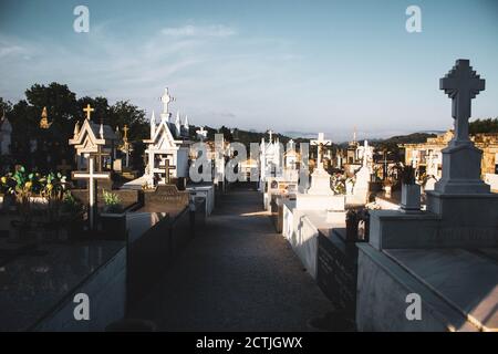 Gräber mit Kreuzen auf einem Friedhof tagsüber gegen blauen Himmel Stockfoto