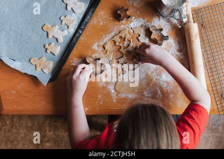 Overhead-Ansicht eines Mädchens mit Ausstechformen zu machen Lebkuchenmann Stockfoto