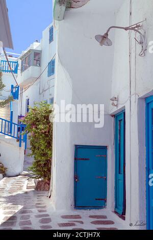 Schmale Straße auf der griechischen Insel Mykonos, mit seinen typischen weißen Häusern und blauen Türen und Fenstern Stockfoto
