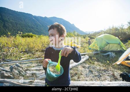 Kleiner Junge, der seine Nase beim Frühstück Haferflocken essen Stockfoto