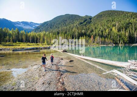 Zwei Jungs erkunden und spielen keinen abgelegenen Strand in British Columbia, Kanada Stockfoto