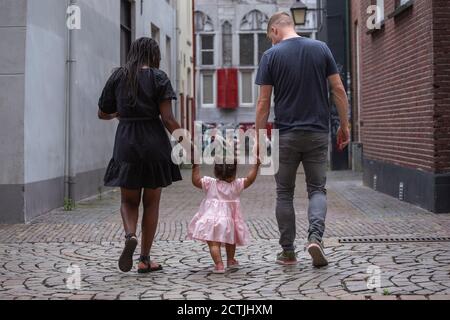 Eine junge Familie, die durch die Straßen eines Europäerin spazierengeht Stadt Stockfoto