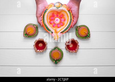 Happy Diwali - Ton Diya Lampen leuchten bei Dipavali, hinduistische Lichterfest feiern. Bunte traditionelle Öllampe diya auf weißem Holz- backgroun Stockfoto