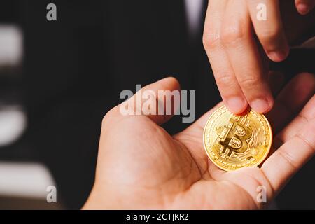 Cryptocurrency Münzen Bitcoin, Frauen halten Sie die cryptocurrency Münze in der Hand. Geldwechsel Stockfoto