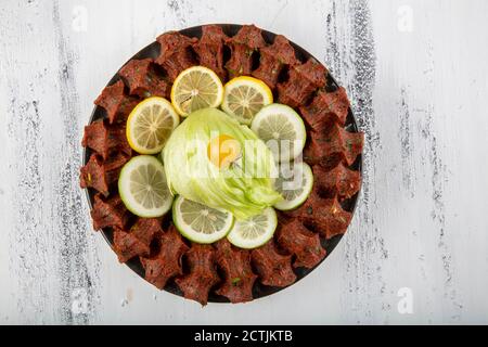 CIG kofte, ein rohes Fleischgericht in türkischer und armenischer Küche. Türkisches Cig bedeutet "roh" und Kofte bedeutet Fleischbällchen türkisches Essen rohe Zigarette Rolle auf Holz Stockfoto