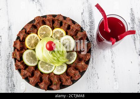 CIG kofte, ein rohes Fleischgericht in türkischer und armenischer Küche. Türkisches Cig bedeutet "roh" und Kofte bedeutet Fleischbällchen türkisches Essen rohe Zigarette Rolle auf Holz Stockfoto