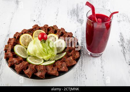 CIG kofte, ein rohes Fleischgericht in türkischer und armenischer Küche. Türkisches Cig bedeutet "roh" und Kofte bedeutet Fleischbällchen türkisches Essen rohe Zigarette Rolle auf Holz Stockfoto