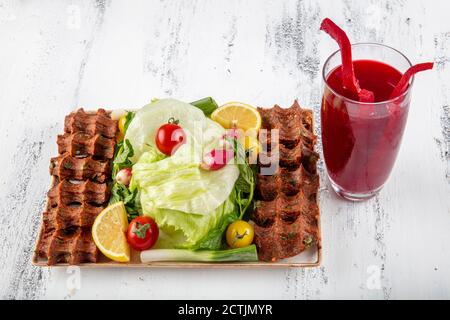 CIG kofte, ein rohes Fleischgericht in türkischer und armenischer Küche. Türkisches Cig bedeutet "roh" und Kofte bedeutet Fleischbällchen türkisches Essen rohe Zigarette Rolle auf Holz Stockfoto