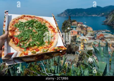 Hand hält eine Pizza-Box in Vernazza, Cinque Terre, italienische Pizza-Tapete, Italien Stockfoto