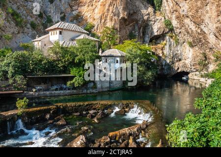 Blagaj, Bosnien und Herzegowina - 04 Sep 2019: Blagaj Tekija Derwisch Kloster und Wasserfall mit riesigen Felsen in der Hintergrundtapete Stockfoto