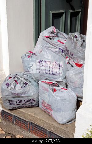 Ocado Kunststoff-Tragetaschen vor der Haustür für die Sammlung durch den Fahrer recycelt und in neue Taschen gemacht werden. Die Sammlung wurde aufgrund des Coronavirus ausgesetzt Stockfoto