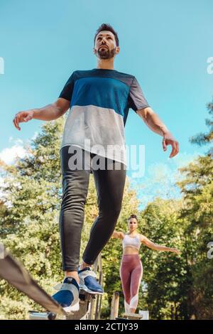 Mann balanciert auf Slackline auf einem Fitness-Parcours Stockfoto