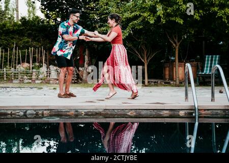 Männer und Frauen tanzen am Pool Stockfoto