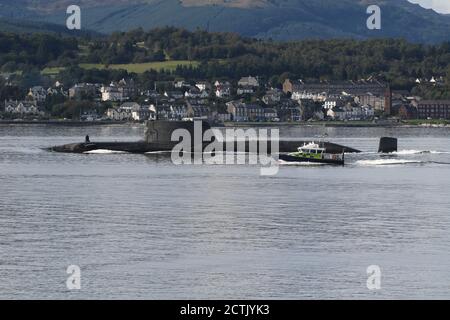 Ein U-Boot der Spitzenklasse, das von der Royal Navy betrieben wird und kurz nach der Abfahrt von der Faslane-Basis den Firth of Clyde abfährt, mit einer Polizeieskorte des Verteidigungsministeriums in Form des Schiffes MDP Barra der Inselklasse. Stockfoto