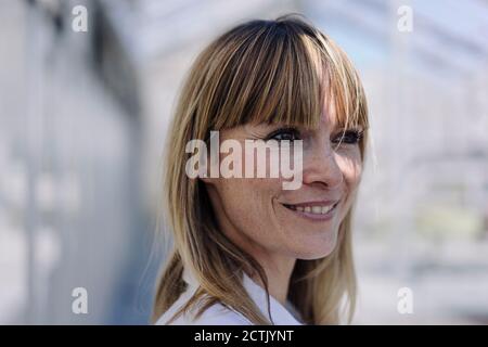 Nahaufnahme einer nachdenklichen professionellen Frau, die im Gewächshaus wegschaut Stockfoto