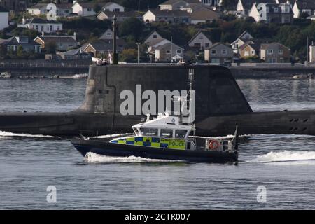 Ein U-Boot der Spitzenklasse, das von der Royal Navy betrieben wird und kurz nach der Abfahrt von der Faslane-Basis den Firth of Clyde abfährt, mit einer Polizeieskorte des Verteidigungsministeriums in Form des Schiffes MDP Barra der Inselklasse. Stockfoto