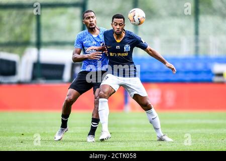 Der belgische Fußballspieler Mousa Dembele aus Guangzhou R&F F.C., rechts, kämpft um den Ball gegen den venezolanischen Fußballspieler Salomon Rondon aus Dalian Stockfoto