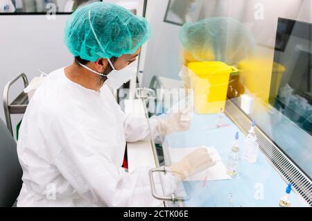 Männlicher Apotheker, der Medikamente am Schreibtisch im Labor macht Stockfoto