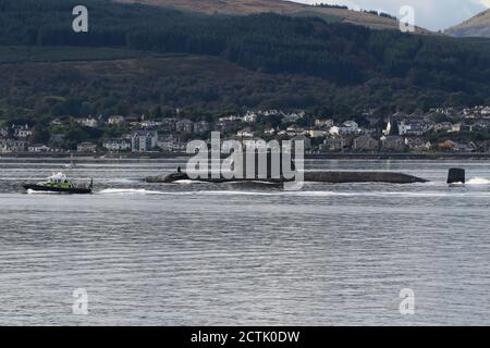 Ein U-Boot der Spitzenklasse, das von der Royal Navy betrieben wird und kurz nach der Abfahrt von der Faslane-Basis den Firth of Clyde abfährt, mit einer Polizeieskorte des Verteidigungsministeriums in Form des Schiffes MDP Barra der Inselklasse. Stockfoto