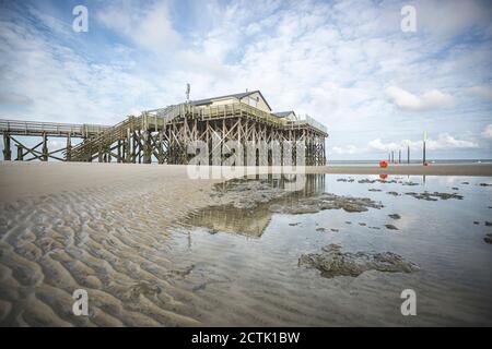 Deutschland, Schleswig-Holstein, Sankt Peter-Ording, Sandstrand mit Pier im Hintergrund Stockfoto