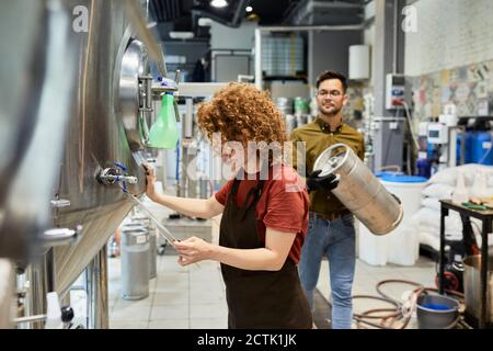 Mann und Frau arbeiten in der handwerklichen Brauerei Stockfoto