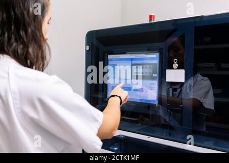 Nahaufnahme der Apothekerin, die die Medizin betreibt und Maschinen im Krankenhaus organisiert Stockfoto