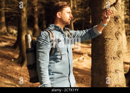 Mittlerer Erwachsener, der mit dem Mobiltelefon fotografiert, während er im Hotel steht Wald Stockfoto