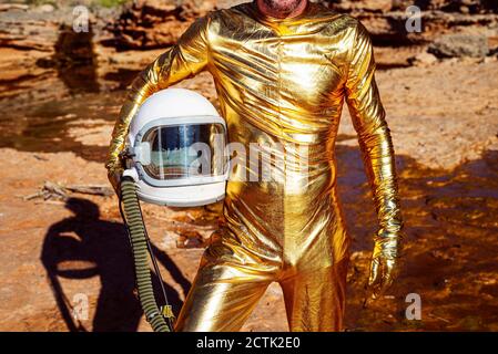Nahaufnahme eines Astronauten, der den Weltraumhelm im Stehen in der Nähe der Taille hält Auf dem Mond Stockfoto