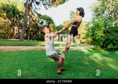 Männliche und weibliche Athleten üben acroyoga im Park Stockfoto