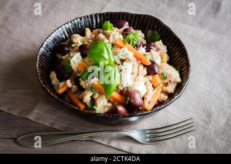 Schüssel mit vegetarischen Spätzle mit Karotten, Oliven, Feta-Käse und Basilikum Stockfoto