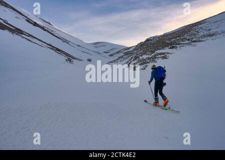 Junger Mann Skilanglauf auf Sibillini Berg bei Sonnenuntergang, Umbrien, Italien Stockfoto