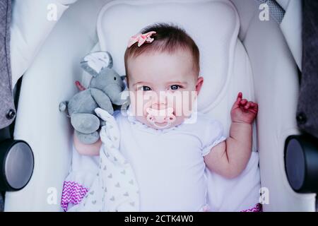 Happy Baby Mädchen liegt im Kinderwagen Stockfoto