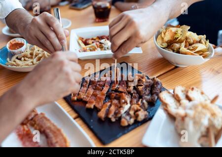 Hände von Freunden genießen frische Mahlzeit im Restaurant Stockfoto