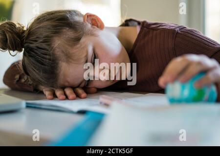 Trauriges Mädchen mit Globus schlafen auf Studie Tisch Stockfoto