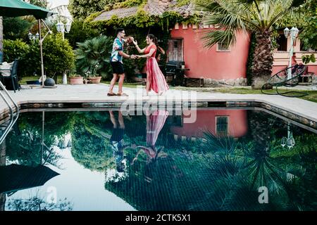 Männer und Frauen tanzen am Pool Stockfoto