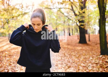 Junge Joggerin im Herbstwald Stockfoto