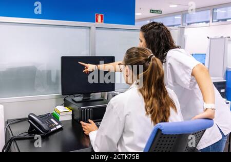 Apothekerinnen diskutieren über Computer im Krankenhaus Stockfoto