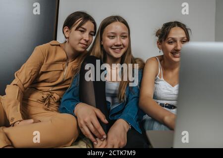 Gruppe von Freundinnen sitzen auf dem Bett, Film auf Laptop Stockfoto