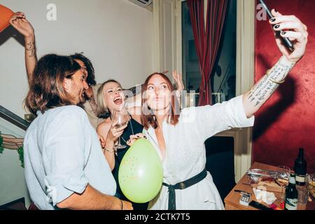 Fröhliche Freunde nehmen Selfie während der Party zu Hause tanzen Stockfoto