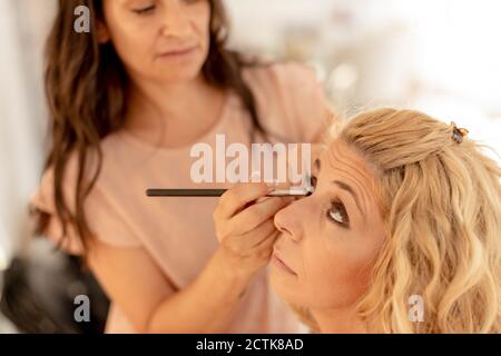 Nahaufnahme der Kosmetikerin Anwendung Eyeliner auf Kunden in Beauty Spa Stockfoto