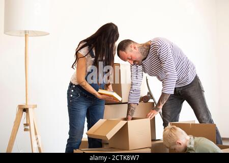 Familie Auspacken Pappkartons gegen die Wand im neuen Haus Stockfoto